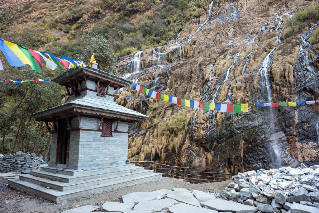 Petit temple bouddhiste et cascades tombant dans la Modi Khola